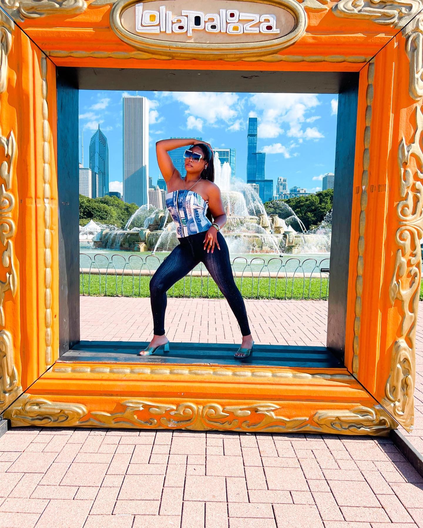 Micah standing in the Lollapalooza Chicago picture frame at Buckingham Fountain, capturing behind-the-scenes creator moments at the 2022 festival.