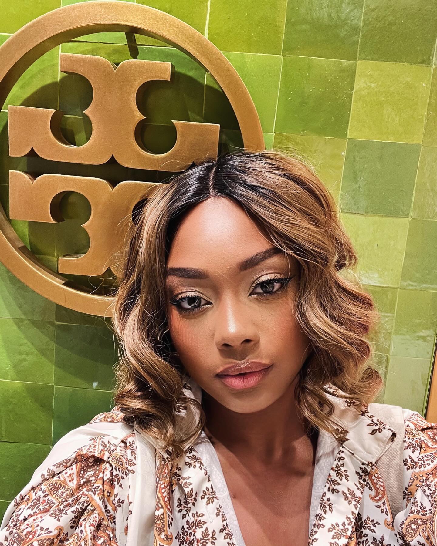 Micah selfie in front of the Tory Burch store logo at NorthPark Mall Dallas, celebrating women empowerment with the Tory Burch Foundation event.